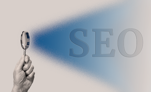 image of Man hand with magnifying glass with blue ray coming from loupe showing SEO